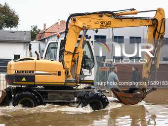 A couple rides on a digger after Nysa Klodzka river flooded town of Lewin Brzeski in southwestern Poland, on September 19th, 2024. Storm Bor...