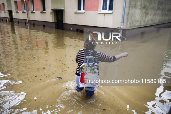 A woman walks the street in the water after Nysa Klodzka river flooded town of Lewin Brzeski in southwestern Poland, on September 19th, 2024...