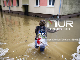 A woman walks the street in the water after Nysa Klodzka river flooded town of Lewin Brzeski in southwestern Poland, on September 19th, 2024...