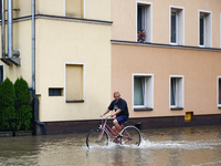 A resident rides a bicycle in the water after Nysa Klodzka river flooded town of Lewin Brzeski in southwestern Poland, on September 19th, 20...