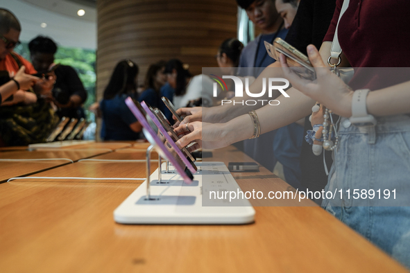 Customers try out the latest iPhone 16 models at an Apple store in Bangkok, Thailand, on September 20, 2024. Apple now makes available to co...