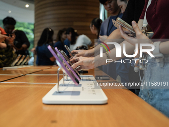 Customers try out the latest iPhone 16 models at an Apple store in Bangkok, Thailand, on September 20, 2024. Apple now makes available to co...