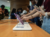 Customers try out the latest iPhone 16 models at an Apple store in Bangkok, Thailand, on September 20, 2024. Apple now makes available to co...