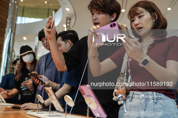 Customers try out the latest iPhone 16 models at an Apple store in Bangkok, Thailand, on September 20, 2024. Apple now makes available to co...