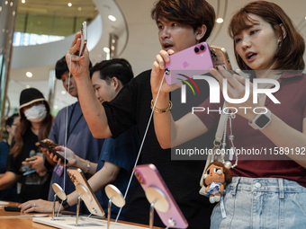 Customers try out the latest iPhone 16 models at an Apple store in Bangkok, Thailand, on September 20, 2024. Apple now makes available to co...