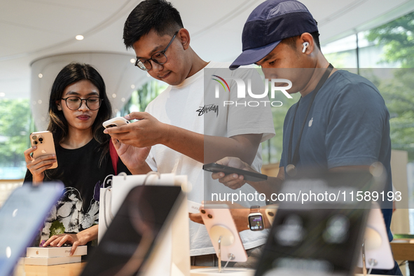 Customers try out the latest iPhone 16 models at an Apple store in Bangkok, Thailand, on September 20, 2024. Apple now makes available to co...