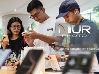 Customers try out the latest iPhone 16 models at an Apple store in Bangkok, Thailand, on September 20, 2024. Apple now makes available to co...