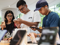 Customers try out the latest iPhone 16 models at an Apple store in Bangkok, Thailand, on September 20, 2024. Apple now makes available to co...