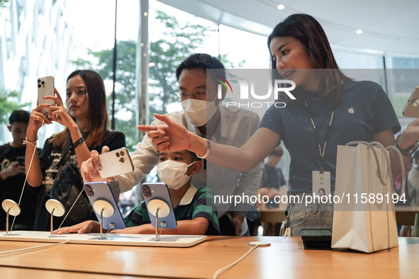 Customers try out the latest iPhone 16 models at an Apple store in Bangkok, Thailand, on September 20, 2024. Apple now makes available to co...