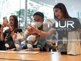 Customers try out the latest iPhone 16 models at an Apple store in Bangkok, Thailand, on September 20, 2024. Apple now makes available to co...