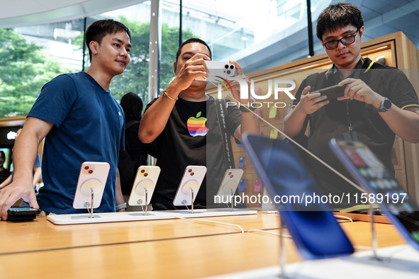 Customers try out the latest iPhone 16 models at an Apple store in Bangkok, Thailand, on September 20, 2024. Apple now makes available to co...