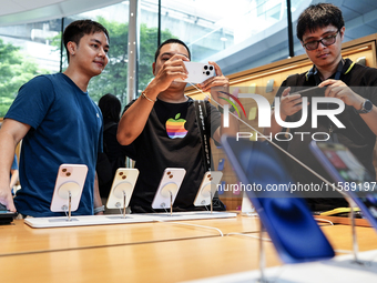 Customers try out the latest iPhone 16 models at an Apple store in Bangkok, Thailand, on September 20, 2024. Apple now makes available to co...