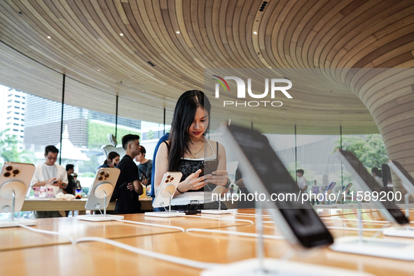 Customers try out the latest iPhone 16 models at an Apple store in Bangkok, Thailand, on September 20, 2024. Apple now makes available to co...