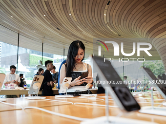 Customers try out the latest iPhone 16 models at an Apple store in Bangkok, Thailand, on September 20, 2024. Apple now makes available to co...