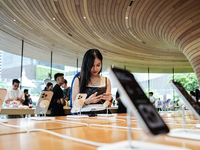 Customers try out the latest iPhone 16 models at an Apple store in Bangkok, Thailand, on September 20, 2024. Apple now makes available to co...