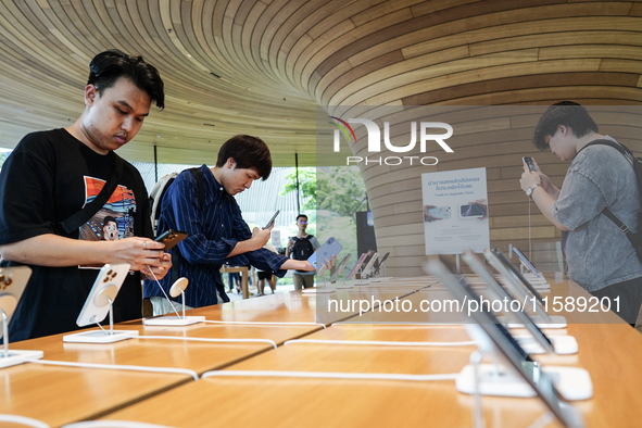 Customers try out the latest iPhone 16 models at an Apple store in Bangkok, Thailand, on September 20, 2024. Apple now makes available to co...