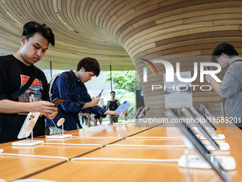 Customers try out the latest iPhone 16 models at an Apple store in Bangkok, Thailand, on September 20, 2024. Apple now makes available to co...