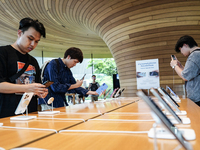 Customers try out the latest iPhone 16 models at an Apple store in Bangkok, Thailand, on September 20, 2024. Apple now makes available to co...