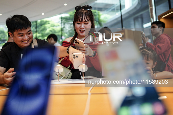 Customers try out the latest iPhone 16 models at an Apple store in Bangkok, Thailand, on September 20, 2024. Apple now makes available to co...