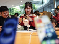 Customers try out the latest iPhone 16 models at an Apple store in Bangkok, Thailand, on September 20, 2024. Apple now makes available to co...