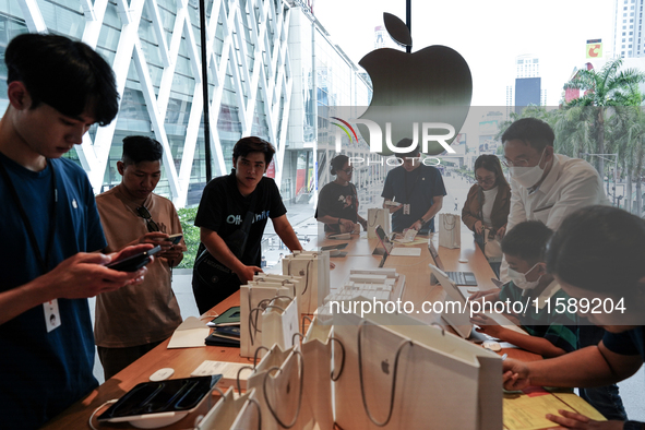 Customers try out the latest iPhone 16 models at an Apple store in Bangkok, Thailand, on September 20, 2024. Apple now makes available to co...