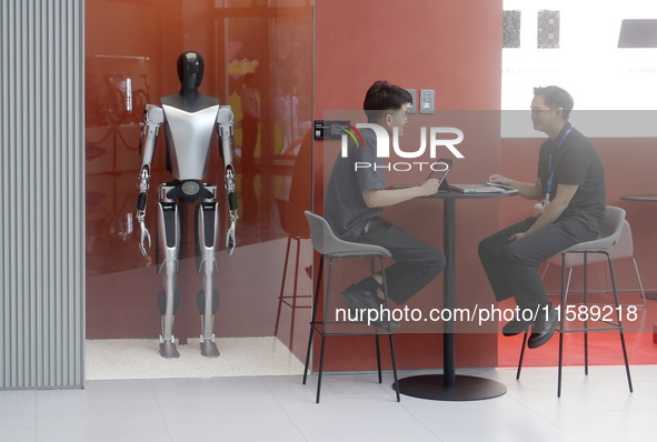 Electric cars and humanoid AI robots are displayed at a new Tesla store in Shanghai, China, on August 9, 2024. 