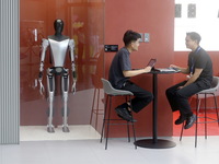 Electric cars and humanoid AI robots are displayed at a new Tesla store in Shanghai, China, on August 9, 2024. (