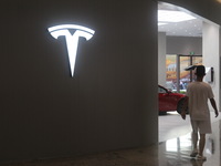 Electric cars and humanoid AI robots are displayed at a new Tesla store in Shanghai, China, on August 9, 2024. (