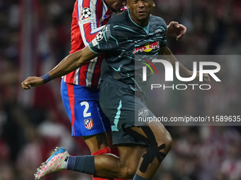 Lois Openda centre-forward of RB Leipzig and Belgium and Jose Maria Gimenez centre-back of Atletico de Madrid and Uruguay compete for the ba...