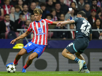 Marcos Llorente central midfield of Atletico de Madrid and Spain and David Raum left-Back of RB Leipzig and Germany compete for the ball dur...