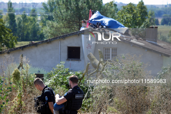 Two gendarmes stand guard in front of the 'Verger' house where a banner reads 'ZAD'. For the fourth day, the Gendarmerie and CNAMO try to di...