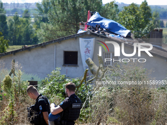 Two gendarmes stand guard in front of the 'Verger' house where a banner reads 'ZAD'. For the fourth day, the Gendarmerie and CNAMO try to di...