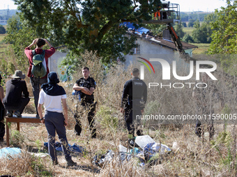 Zadists look at an alod ash tree which will be cut as the 'ecureuil' (i.e., squirrel) living in it has been arrested by Canmo policemen. Can...