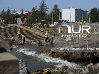 Members of the Polish armed forces and workers remove remnants of a bridge in the flood-hit town of Glucholazy, Poland, on September 20, 202...