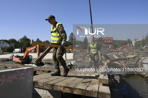 Members of the Polish armed forces and workers remove remnants of a bridge in the flood-hit town of Glucholazy, Poland, on September 20, 202...