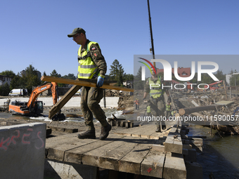 Members of the Polish armed forces and workers remove remnants of a bridge in the flood-hit town of Glucholazy, Poland, on September 20, 202...