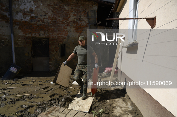 A member of the Polish armed forces removes debris from a house in the flood-hit town of Glucholazy, Poland, on September 20, 2024. 