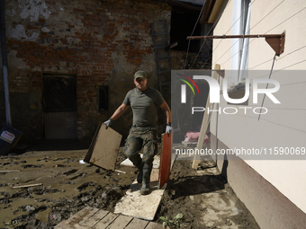 A member of the Polish armed forces removes debris from a house in the flood-hit town of Glucholazy, Poland, on September 20, 2024. (