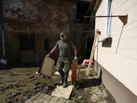 A member of the Polish armed forces removes debris from a house in the flood-hit town of Glucholazy, Poland, on September 20, 2024. (