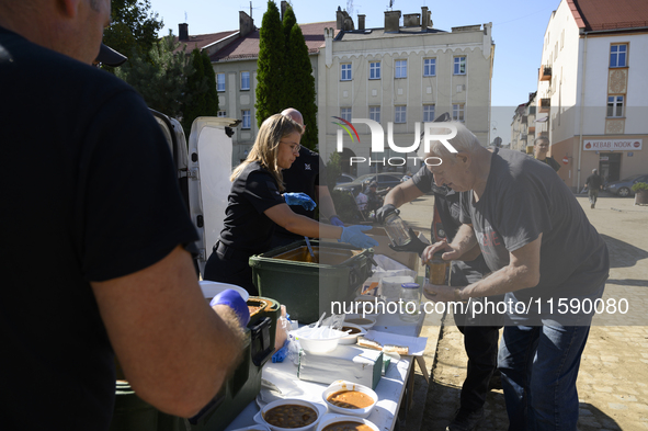 An elderly man receives food in the flood-hit town of Glucholazy, Poland, on September 20, 2024. 