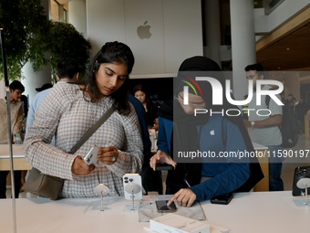 Customers browse iPhone 16 on the launch day of the iPhone 16 series at Apple BKC, in Mumbai, India, on September 20, 2024. The highly await...