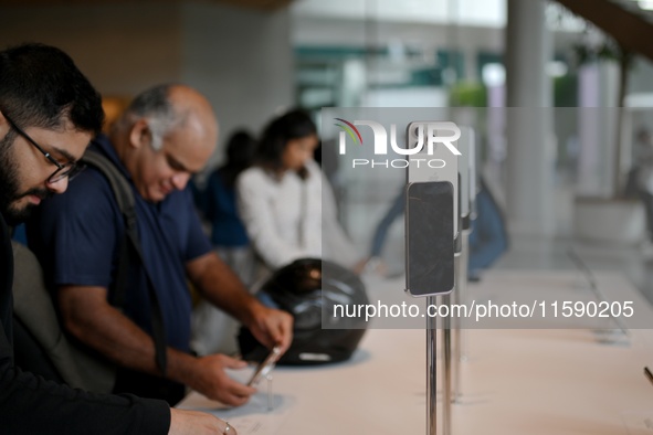 Customers browse iPhone 16 on the launch day of the iPhone 16 series at Apple BKC, in Mumbai, India, on September 20, 2024. The highly await...