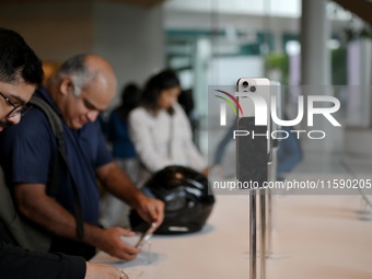 Customers browse iPhone 16 on the launch day of the iPhone 16 series at Apple BKC, in Mumbai, India, on September 20, 2024. The highly await...