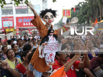 A symbolic puppet display occurs while doctors and citizens hold placards during a protest march and shout slogans, protesting against the r...