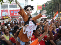 A symbolic puppet display occurs while doctors and citizens hold placards during a protest march and shout slogans, protesting against the r...