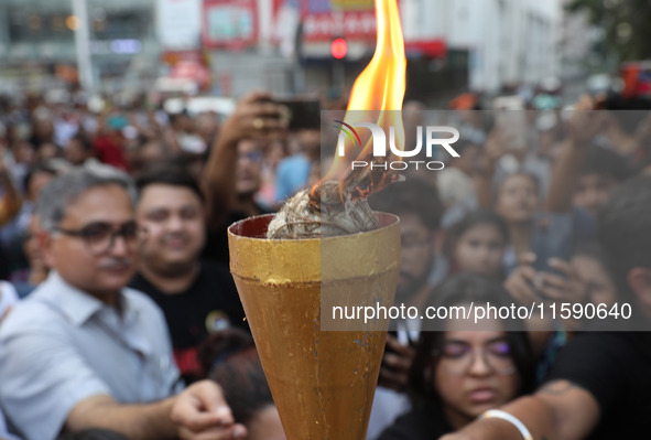 Doctors and citizens hold placards while marching with burning torches during a protest march and shout slogans, protesting against the rape...