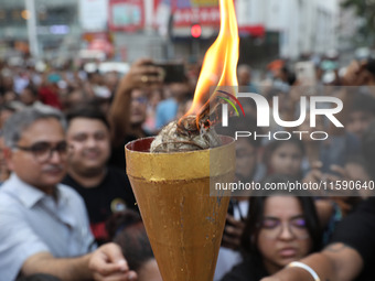 Doctors and citizens hold placards while marching with burning torches during a protest march and shout slogans, protesting against the rape...