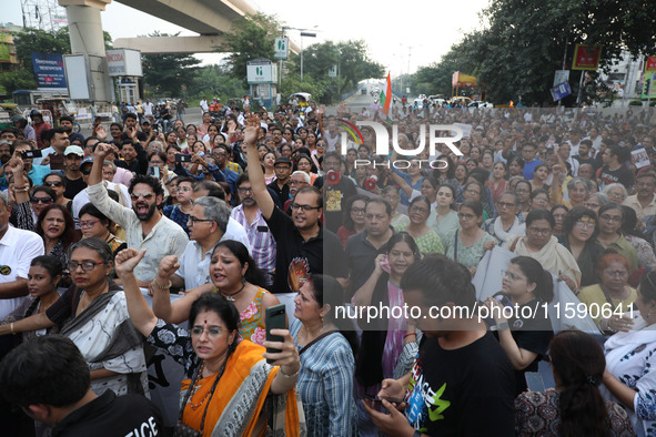 Doctors and citizens hold placards while marching with burning torches during a protest march and shout slogans, protesting against the rape...