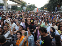 Doctors and citizens hold placards while marching with burning torches during a protest march and shout slogans, protesting against the rape...