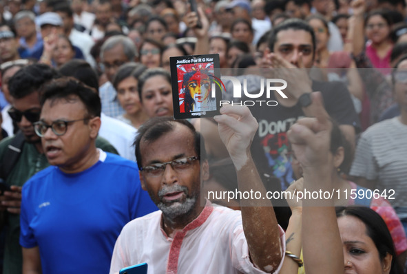 Doctors and citizens hold placards while marching with burning torches during a protest march and shout slogans, protesting against the rape...